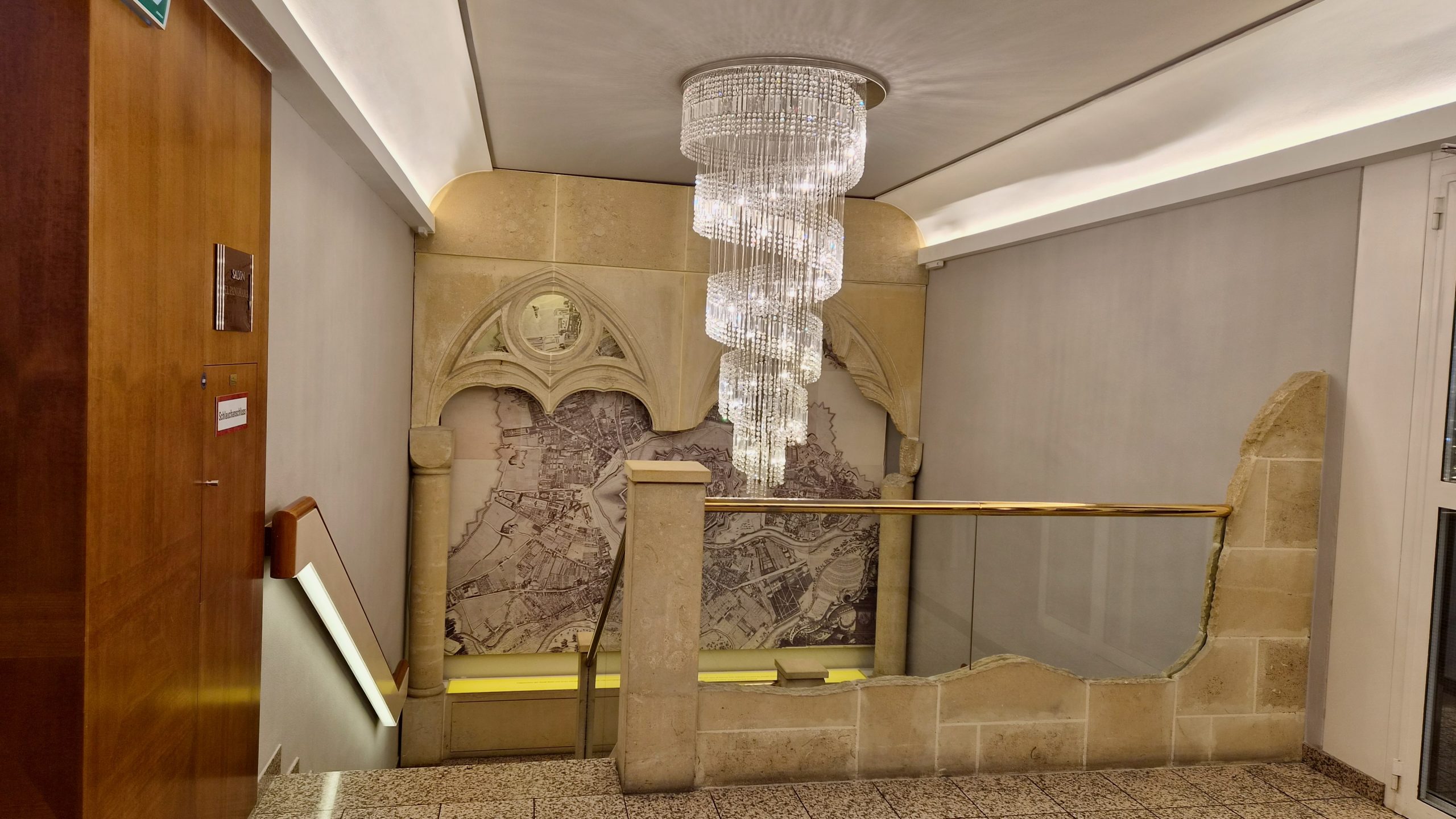 Staircase with gilt details and a crystal chandelier at Hotel Am Parkring, Vienna